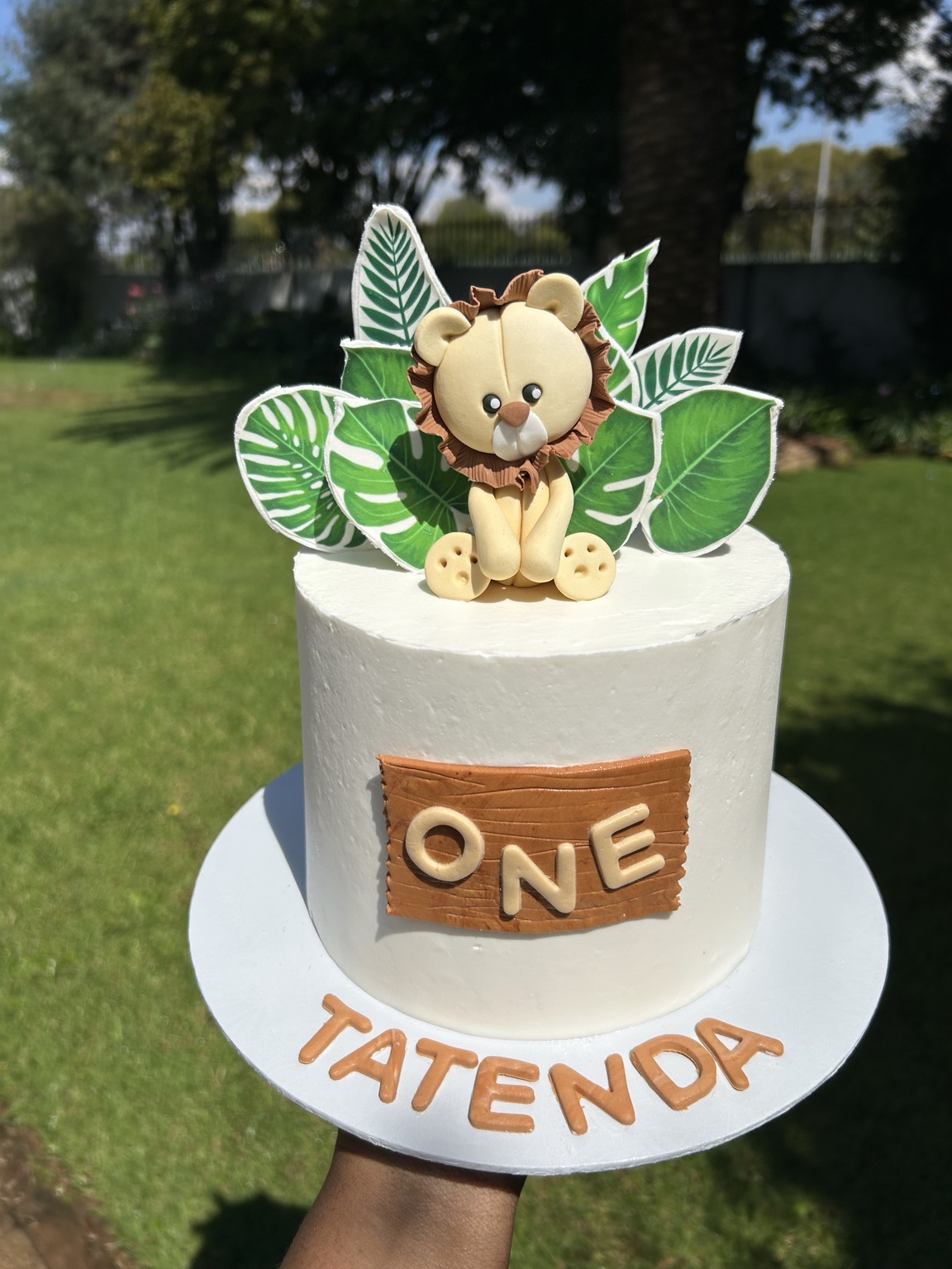 Lion and jungle leaves first birthday cake for Tatenda